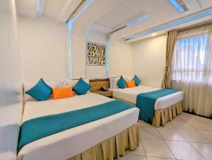 内罗毕梅丽丽酒店的配有两张蓝色和橙色枕头的床铺