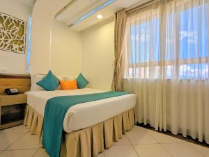 内罗毕梅丽丽酒店的一间卧室设有一张大床和大窗户