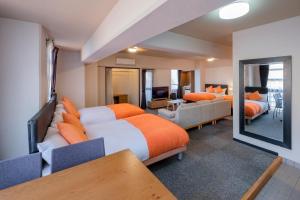 宫崎Miyazaki Mango Hotel的酒店客房带两张床和一个客厅