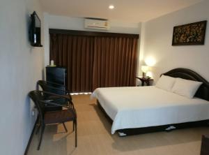 尖竹汶Evergreen Resort Chanthaburi的配有一张床和一把椅子的酒店客房