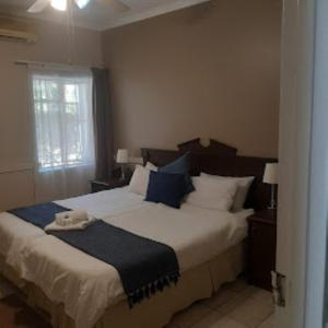 布隆方丹维多利亚山林小屋的一间卧室配有一张带蓝白色枕头的大床