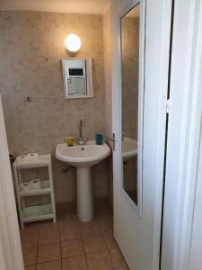 拉纳卡Sea Apartments的浴室设有白色水槽和镜子