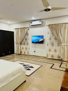 伊斯兰堡The Gateway islamabad的一间卧室配有一张床,墙上配有电视
