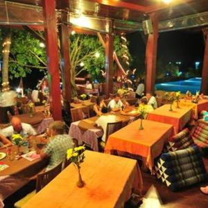 帕干岛Haad Yao Bayview Hotel的一群坐在餐厅桌子上的人