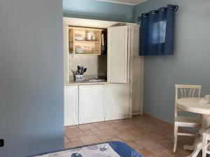 马达莱纳德帕可别墅酒店的厨房配有白色橱柜和蓝色窗帘