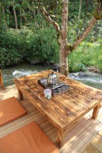 PalayanganSoraCai Riverside Campsite的一张木桌,上面有茶壶