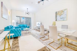 迪拜Elegant 3BR in JBR w/ partial Marina View的客厅配有蓝色的沙发和桌子