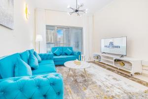 迪拜Elegant 3BR in JBR w/ partial Marina View的客厅配有蓝色的沙发和电视