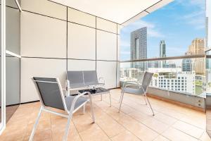 迪拜Elegant 3BR in JBR w/ partial Marina View的大楼内的阳台配有两把椅子和一张桌子