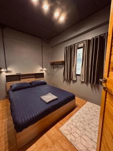 南芭堤雅Hostel Friends Station & Cafe的一间卧室配有一张带蓝色床单的床和一扇窗户。