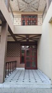 拉合尔6 Bedroom private home in Dha Lahore- Phase1 Entire House的一座带红色门和阳台的建筑