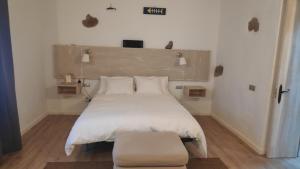 瓜蒂萨Casa Ines的卧室配有一张白色的大床和凳子