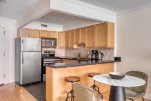 纽约Nolita 1BR w Elevator Roof Deck nr SoHo NYC-907的厨房配有木制橱柜和不锈钢冰箱。