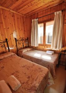 奥尔希瓦奥吉瓦露营酒店的一间卧室设有两张床和窗户。