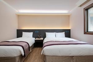 台中市沫秋立柳川行旅的两张位于酒店客房的床,配有两张sidx sidx单人床
