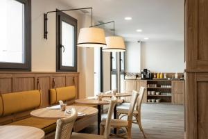 塞维利亚Petit Palace Vargas的餐厅设有木桌、椅子和镜子