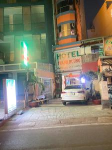 胡志明市Thanh Hương Hotel的夜间停在城市街道上的白色汽车