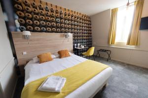乐卡图Logis - Hostellerie & Restaurant du Marché的卧室配有一张白色大床和黄色床单
