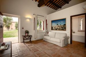 奇尼基亚诺Tenuta Pianirossi的客厅配有白色沙发和窗户