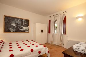 奇尼基亚诺Tenuta Pianirossi的一间卧室配有一张床、一张桌子和一个窗户。