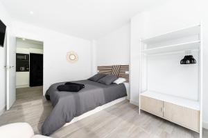 克萨达城Sunrise Bulnes Golf 1的白色卧室配有床和镜子