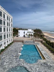 嘎那角Bờ Biển Vàng Hotel的享有大楼旁游泳池和海滩的上方景色
