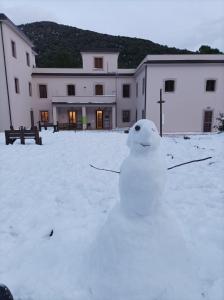 CampodimeleOstello Ossigeno的坐在建筑物前雪地里的雪人