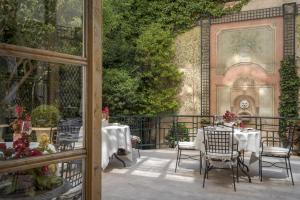 马德里Relais & Châteaux Hotel Orfila的庭院内带桌椅的餐厅