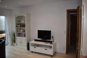 温特贝格Ferienwohnung (H)Auszeit Pape的一间客厅,在白色的橱柜上配有电视