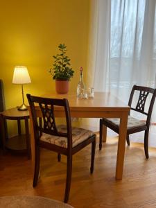 慕尼黑Privatzimmer mit Balkon的一张木桌,配有两把椅子和一张桌子,上面有植物