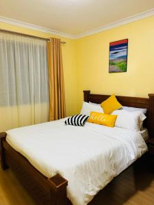 Langata RongaiLovely 2 Bedroom Apartment in Ongata Rongai的一间卧室设有一张黄色墙壁的大床