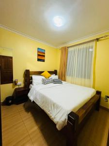 Langata RongaiLovely 2 Bedroom Apartment in Ongata Rongai的一间卧室配有一张带白色床单的大床