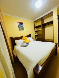 Langata RongaiLovely 2 Bedroom Apartment in Ongata Rongai的一间卧室配有一张带白色床单的大床