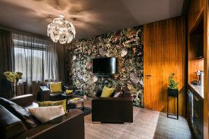 布尔诺Hotel International Brno的客厅配有沙发和墙上的电视