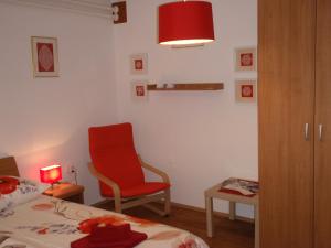 博维茨Sobe Vera的一间卧室配有红色椅子、一张床和一张桌子
