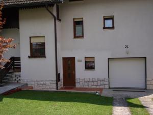 博维茨Sobe Vera的一间白色的房子,设有两个车库门和草地庭院