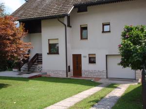 博维茨Sobe Vera的一间白色的房子,有车库和草地庭院