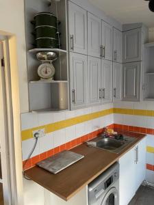 新港Heath Farm cottage的厨房配有白色橱柜和水槽
