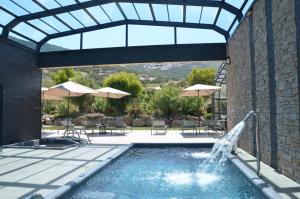 卡尔维Domaine Villas Mandarine Private Pools & Spa的游泳池设有喷泉、桌子和遮阳伞