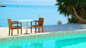 阿马林索斯波尔图埃维亚精品酒店 的游泳池畔的两把椅子和一张桌子
