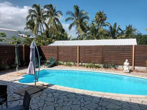 圣保罗La Villa Hibon的一个带遮阳伞的游泳池,位于围栏旁