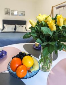 桑多梅日Apartament Żeromskiego 1的一张桌子上一束黄色玫瑰和水果花瓶