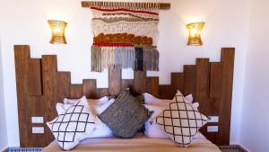 达赫拉Dakhla Attitude的一间卧室配有一张带木制床头板的床