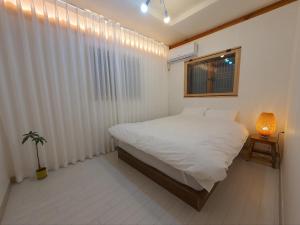 水原市Haenggung stay Dalno - Suwon private house hanok的卧室配有白色的床和窗户。
