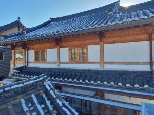 水原市Haenggung stay Dalno - Suwon private house hanok的屋顶上积雪的亚洲建筑