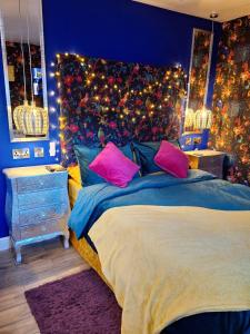 马特洛克Park House Studio的一间卧室配有带粉红色和蓝色枕头的床