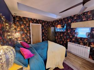 马特洛克Park House Studio的一间卧室配有蓝色的床和电视