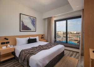 赫尔格达Creek Hotel and Residences El Gouna的酒店客房设有一张床和一个大窗户