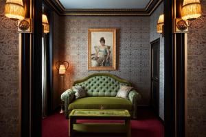 巴黎Maison Souquet, Hotel & Spa的客厅配有绿色沙发和绘画作品