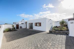 普拉亚布兰卡VILLAS LANZAROTE LOS ALTOS by NEW LANZASUITES Villa SERENA的白色的房子,有石头车道